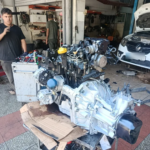 Toplanmış motor ve şanzıman takımı ile tamirhanenin tezgah bölgesi