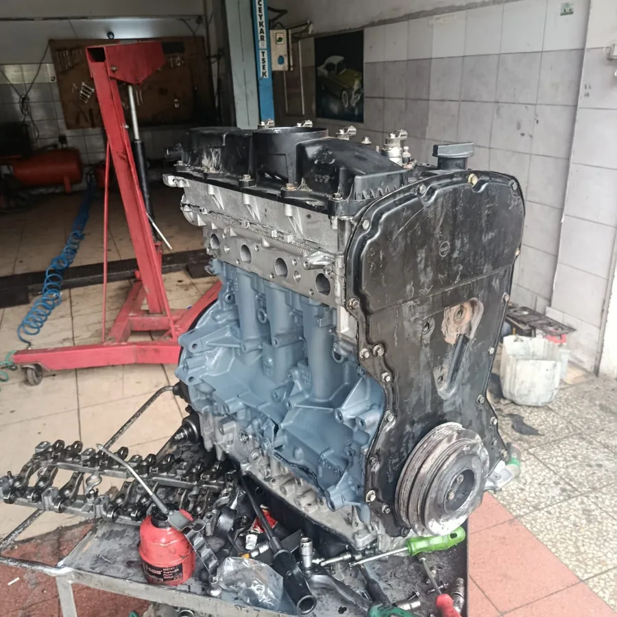 Sehpaya alınmış motor bloğu ve sökülen parçaların dizildiği tezgah
