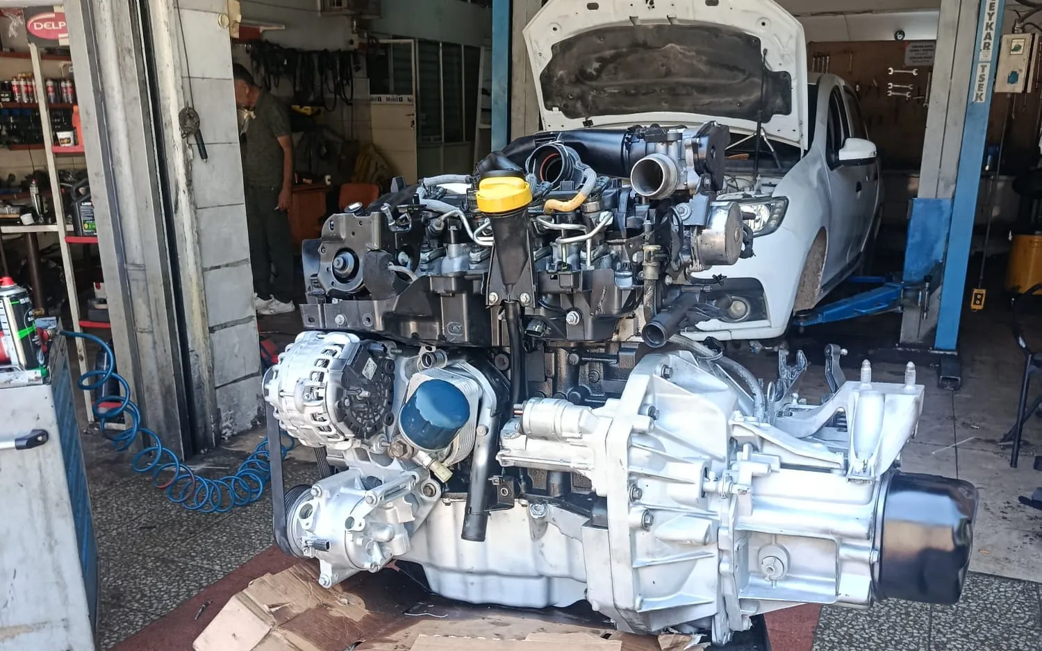 Motor ve şanzıman grubunun sökülüp tamirhanede sehpaya alınmış hâli